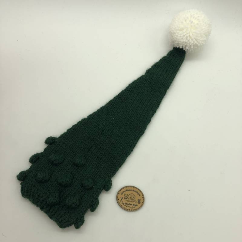 Green knitted hat with white pompon